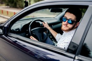 Man wearing sunglasses and car